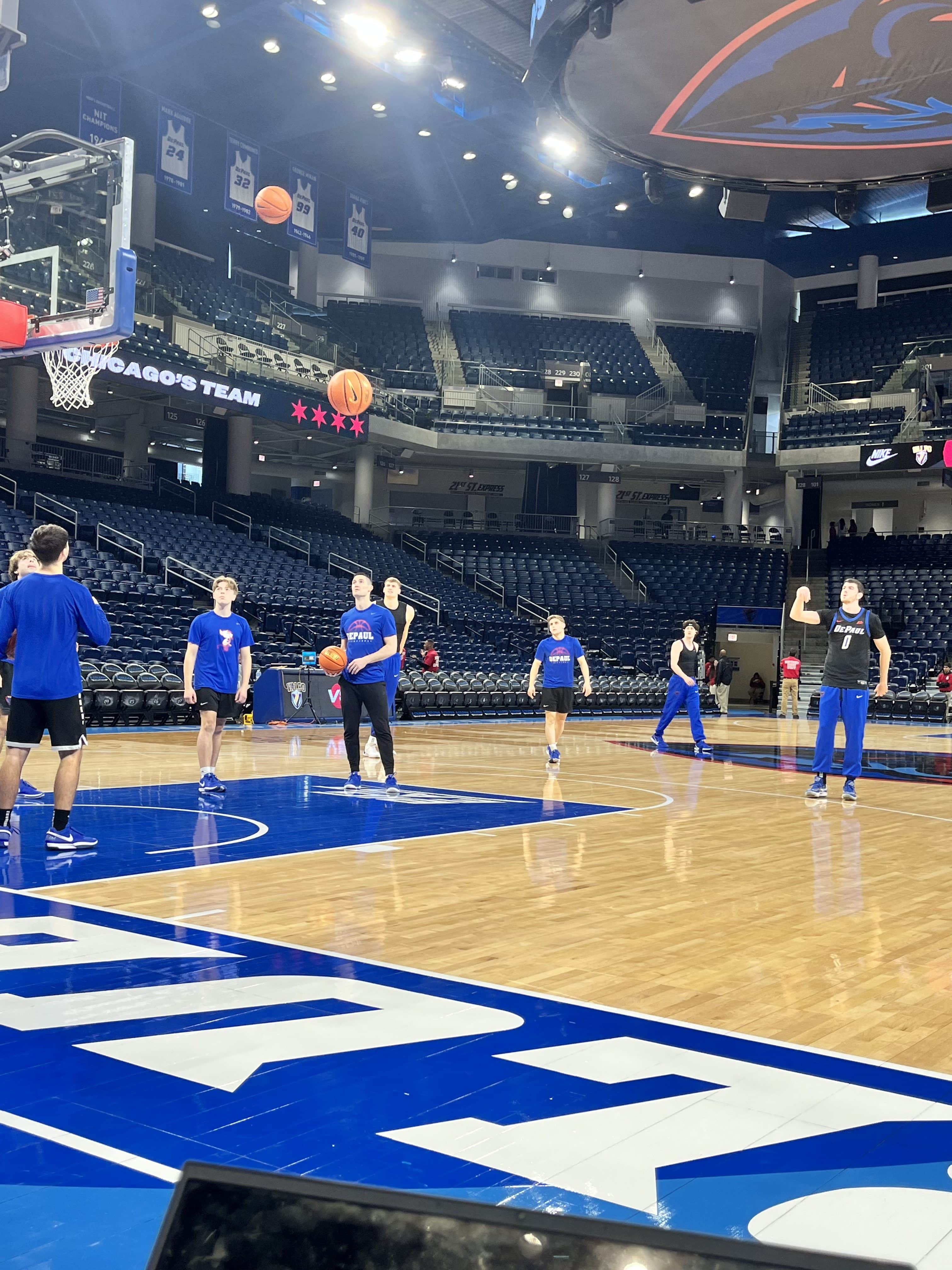 DePaul basketball players David Skogman and Troy D'Amico (0) work on their three-point shooting in pregame warmups