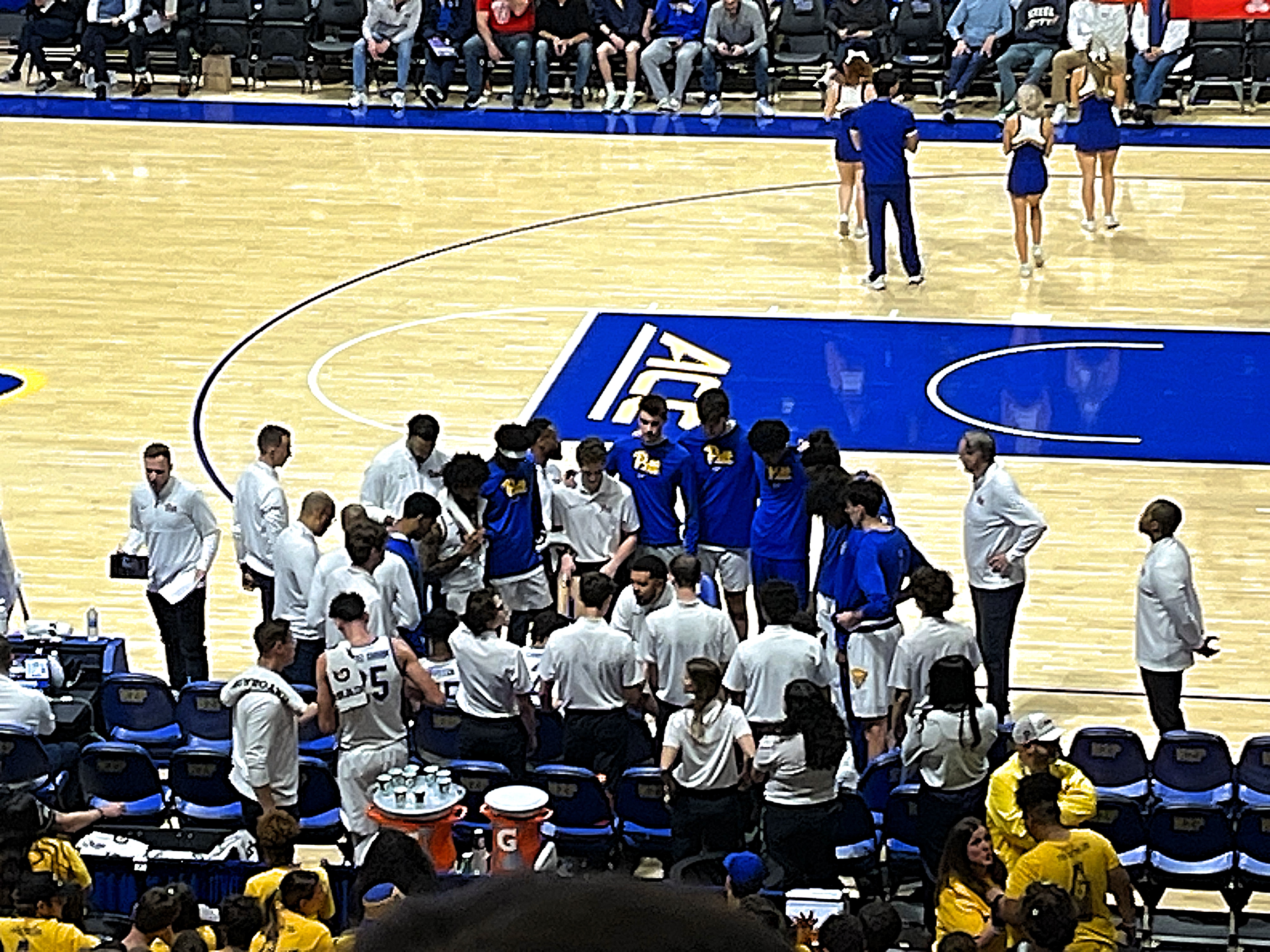 Pitt basketball huddles around head Jeff Capel during a media timeout.